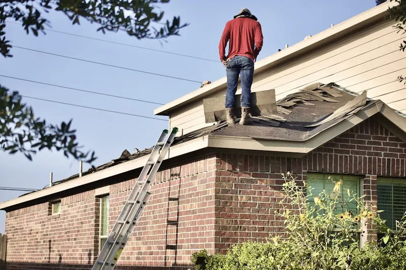 Professional roofer working on a residential roof in Clayville